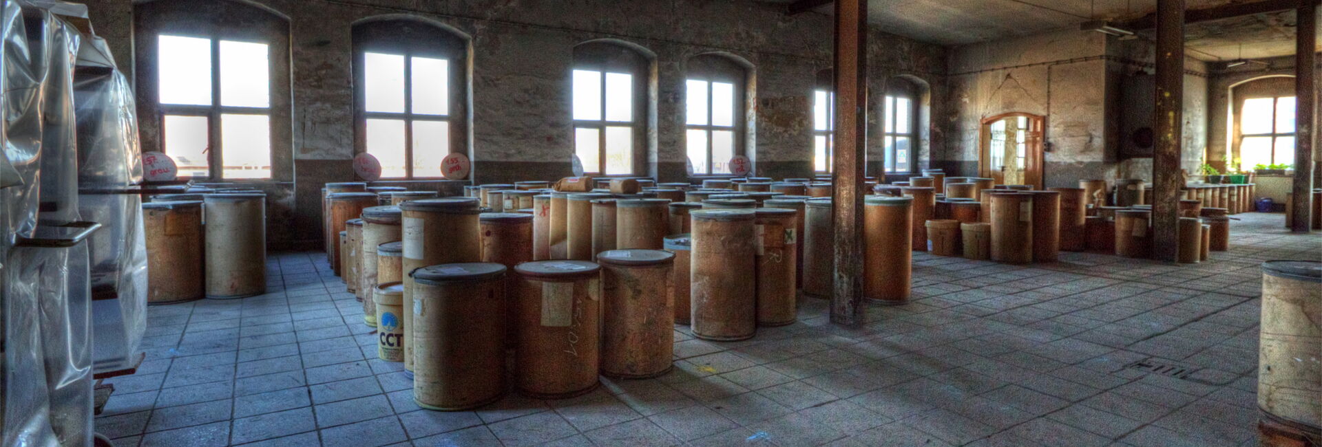 Lagerraum mit vielen Holzfässern und Fenstern.