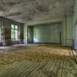 Verlassener Raum mit Sand und alten Fenstern.